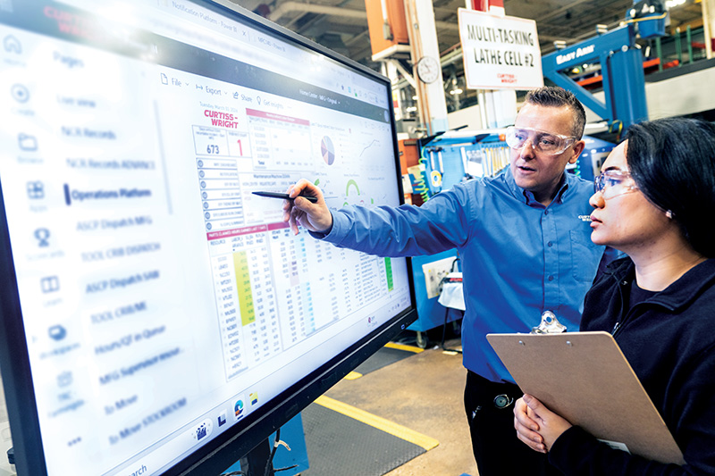 Employees reviewing operational data on a production floor
