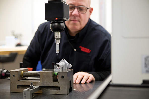 Curtiss-Wright employee inspecting a component